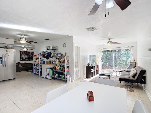 living room featuring a textured ceiling, light tile patterned flooring, and visible vents