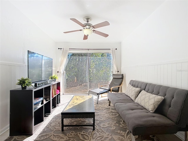 living room with a wainscoted wall and a ceiling fan