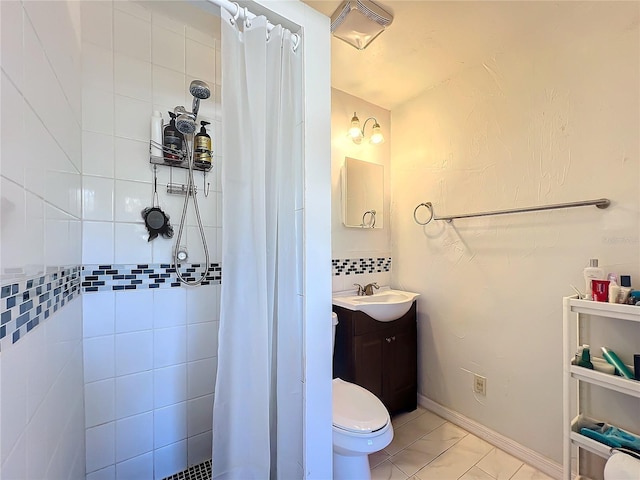 bathroom with a tile shower, vanity, and baseboards