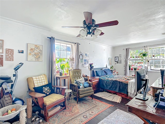 bedroom featuring ceiling fan, wood finished floors, and crown molding