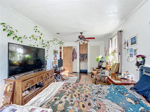 living room featuring a ceiling fan, wood finished floors, visible vents, and crown molding