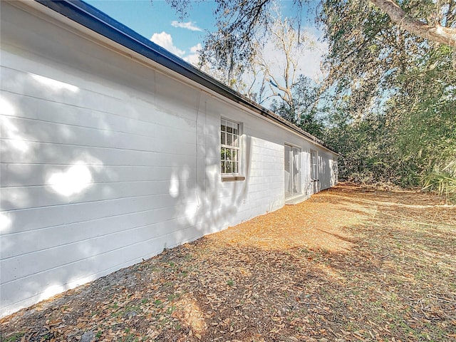 view of side of home featuring concrete block siding