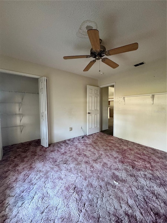 unfurnished bedroom with ceiling fan, a closet, carpet, and a textured ceiling