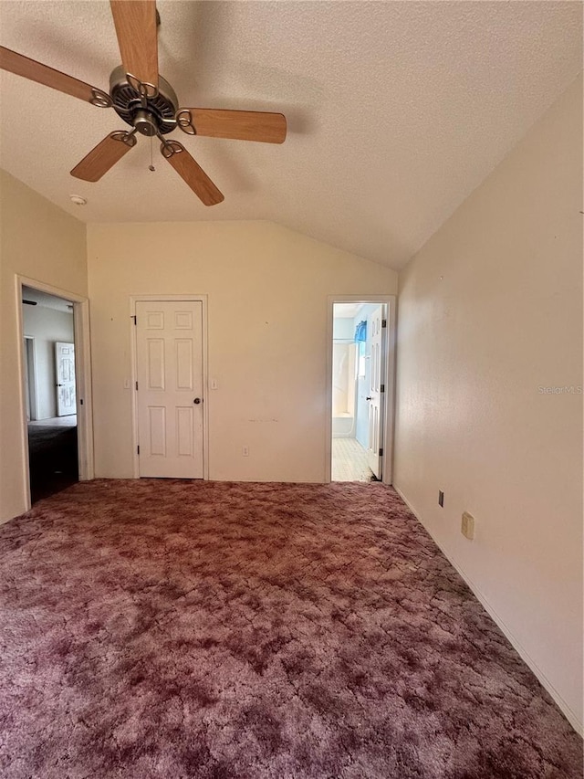 unfurnished room featuring ceiling fan, lofted ceiling, carpet flooring, and a textured ceiling