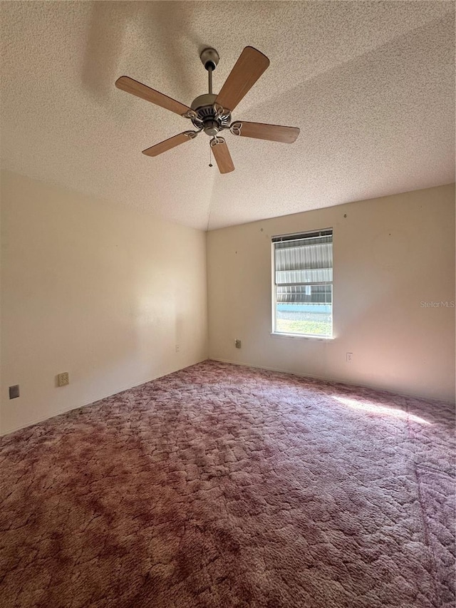 carpeted empty room featuring ceiling fan and a textured ceiling