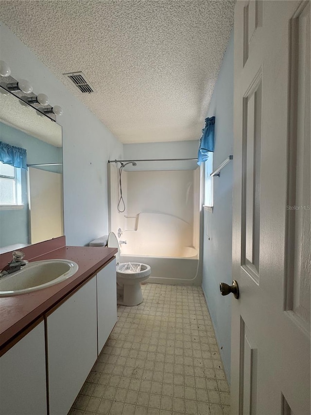 full bathroom featuring vanity, a textured ceiling, shower / bathtub combination, and toilet