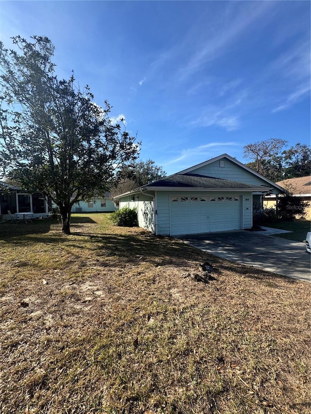 view of side of home with a garage and a lawn