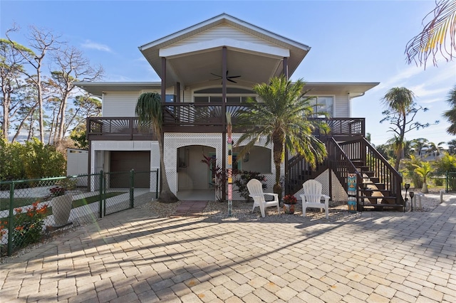 exterior space featuring a garage, a balcony, and ceiling fan