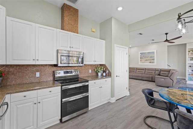 kitchen featuring white cabinetry, stainless steel appliances, and backsplash