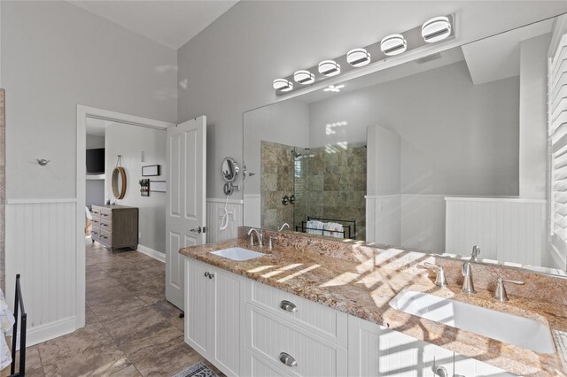 bathroom with a tile shower and vanity