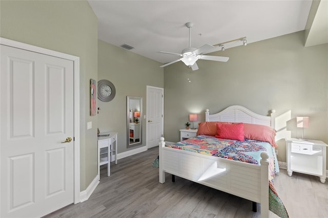 bedroom with ceiling fan, vaulted ceiling, and light wood-type flooring