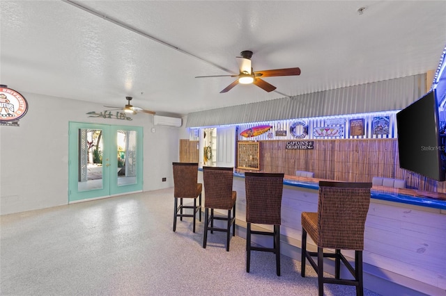 bar with ceiling fan, a textured ceiling, french doors, and a wall mounted AC