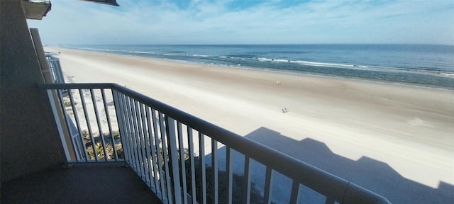 balcony featuring a water view and a view of the beach