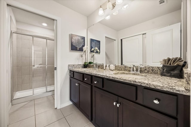 bathroom with tile patterned floors, vanity, and a shower with shower door