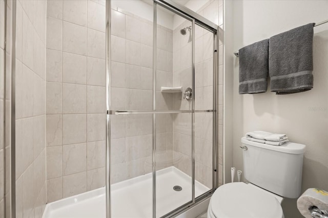 bathroom featuring toilet and an enclosed shower