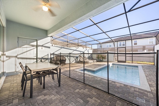 view of pool with ceiling fan, a patio area, and glass enclosure