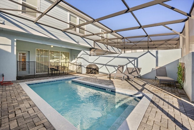 view of swimming pool with a patio and glass enclosure