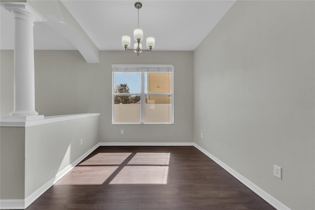 unfurnished dining area featuring dark hardwood / wood-style flooring, beam ceiling, decorative columns, and an inviting chandelier