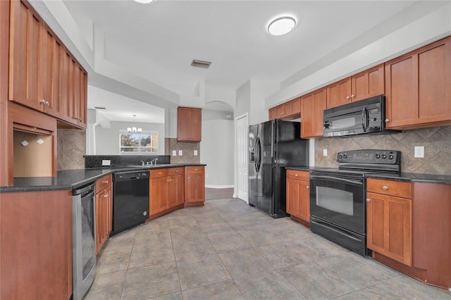 kitchen with tasteful backsplash, kitchen peninsula, a notable chandelier, and black appliances