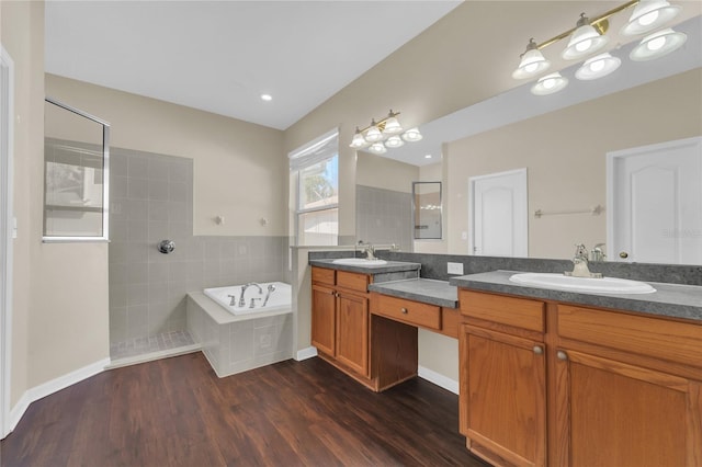 bathroom featuring hardwood / wood-style flooring, vanity, and plus walk in shower