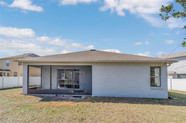 rear view of property with a yard and a sunroom