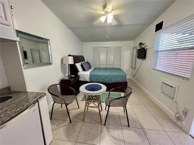 bedroom featuring light tile patterned floors, ceiling fan, a wall mounted air conditioner, vaulted ceiling, and a closet