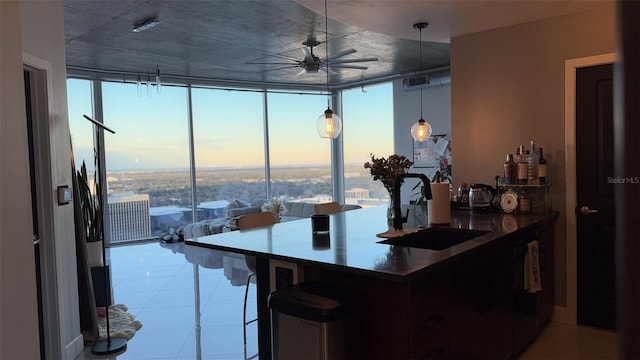 kitchen with ceiling fan, floor to ceiling windows, decorative light fixtures, and sink