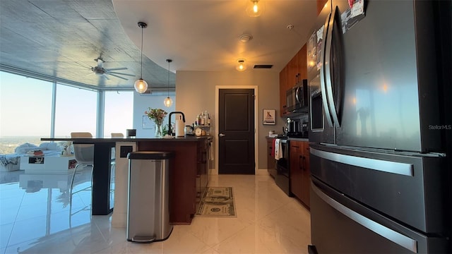 kitchen featuring sink, hanging light fixtures, expansive windows, ceiling fan, and stainless steel appliances