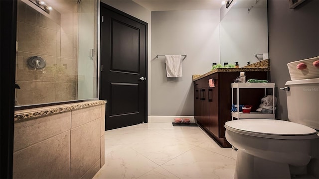 bathroom featuring vanity, a tile shower, and toilet