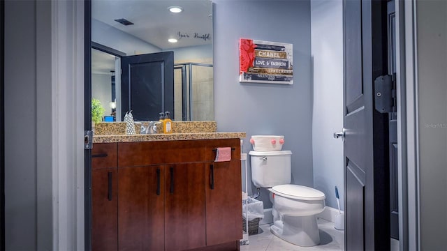 bathroom featuring tile patterned floors, vanity, toilet, and a shower with shower door