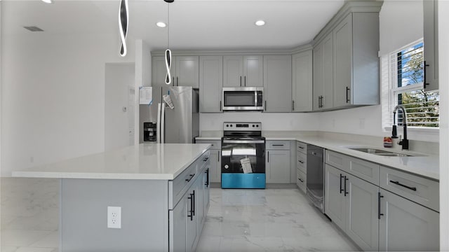 kitchen with pendant lighting, appliances with stainless steel finishes, gray cabinets, and sink