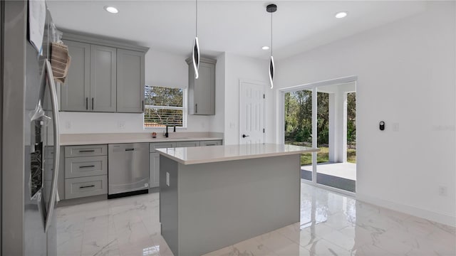 kitchen featuring sink, gray cabinetry, decorative light fixtures, a center island, and appliances with stainless steel finishes