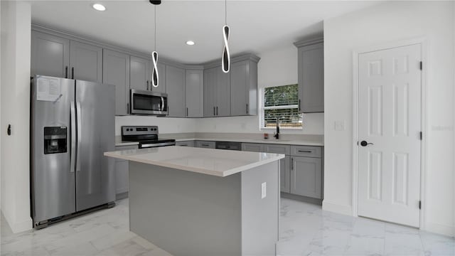 kitchen featuring appliances with stainless steel finishes, sink, gray cabinetry, hanging light fixtures, and a center island