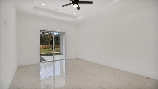 unfurnished room featuring ceiling fan and a tray ceiling