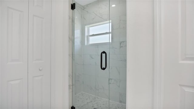 bathroom with a shower with door