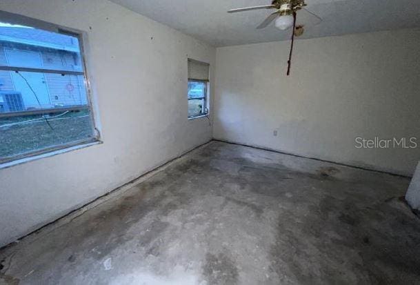 spare room with ceiling fan and concrete flooring