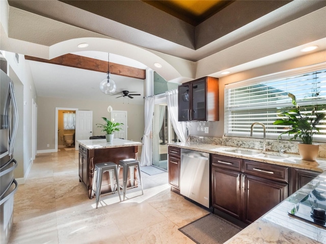 kitchen featuring sink, decorative light fixtures, dark brown cabinets, and appliances with stainless steel finishes