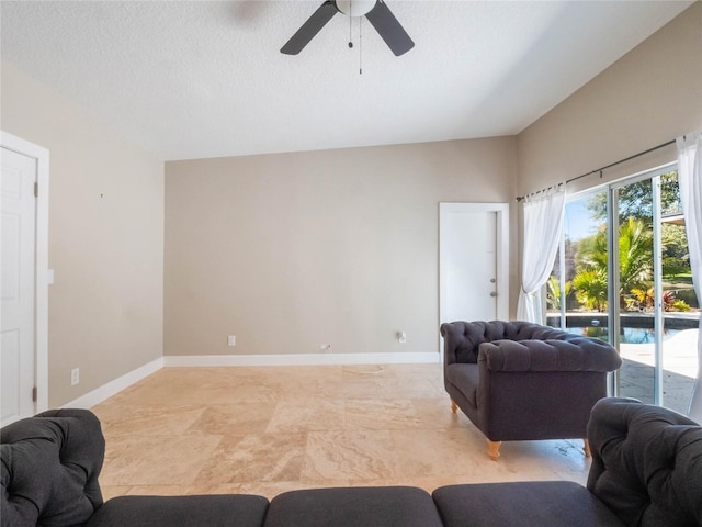 living room featuring ceiling fan, a textured ceiling, and a wealth of natural light