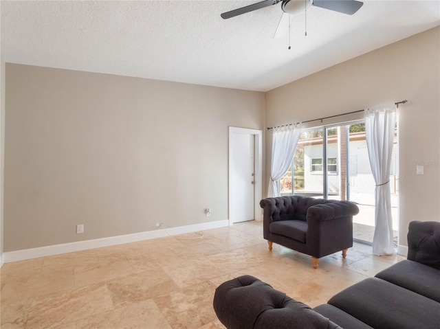 living room featuring ceiling fan and a textured ceiling