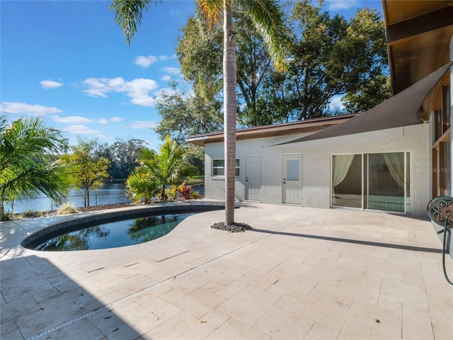 view of swimming pool featuring a water view and a patio area