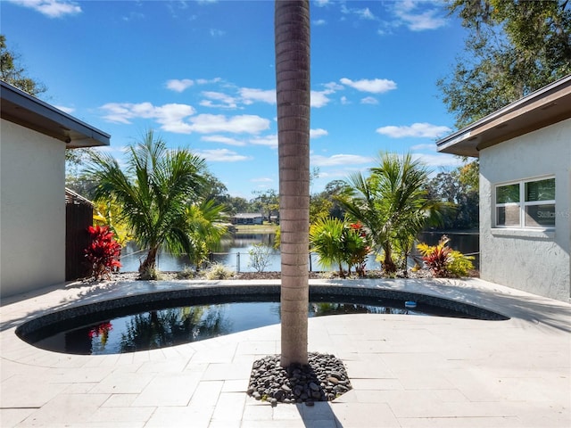 view of pool with a water view and a patio area