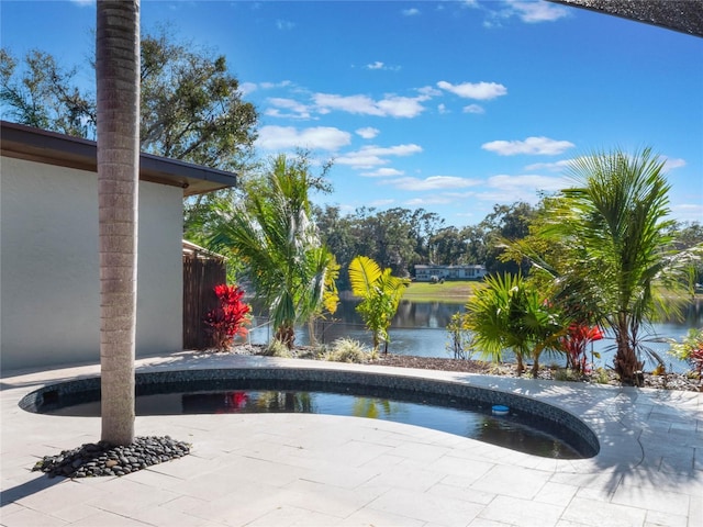 view of swimming pool featuring a water view and a patio area