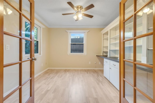 empty room featuring ornamental molding, light hardwood / wood-style flooring, and a textured ceiling