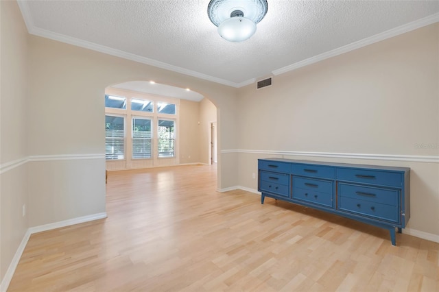 unfurnished room featuring crown molding, light hardwood / wood-style floors, and a textured ceiling