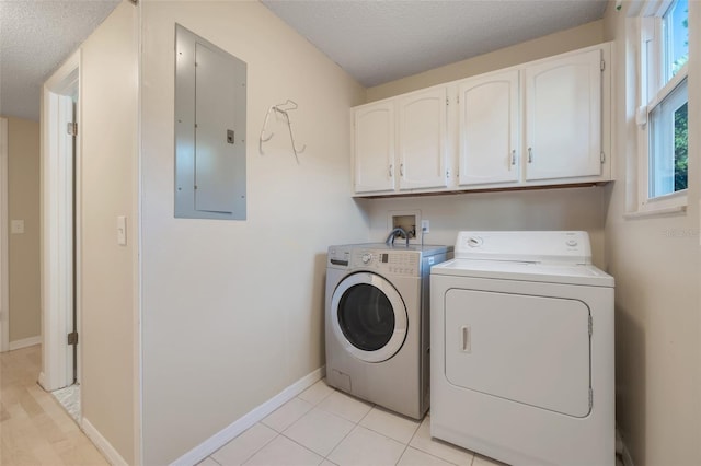 washroom featuring cabinets, light tile patterned floors, electric panel, washing machine and dryer, and a textured ceiling