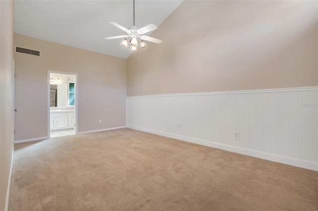 spare room with ceiling fan, light colored carpet, and high vaulted ceiling