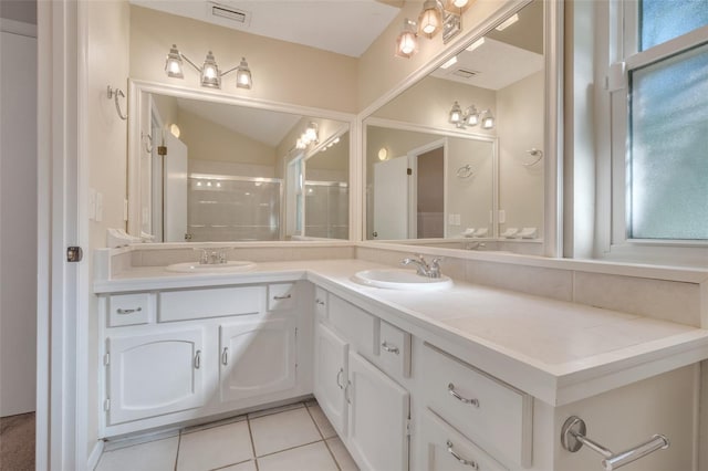 bathroom with tile patterned flooring, vanity, vaulted ceiling, and a shower with door