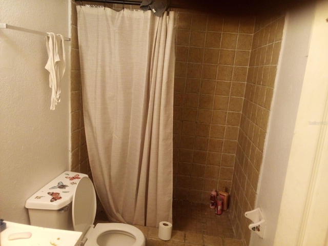 bathroom featuring toilet and a shower with curtain