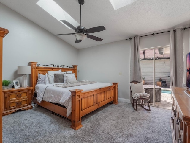 bedroom with lofted ceiling with skylight, carpet, access to outside, ceiling fan, and a textured ceiling