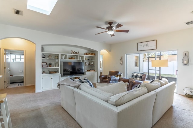 carpeted living room featuring built in features and ceiling fan